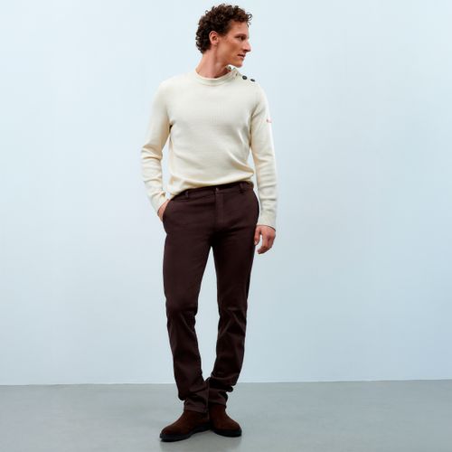 Homme habillé d’un pull marin écru Atelier Tuffery et d’un pantalon en toile chocolat. - Atelier Tuffery
