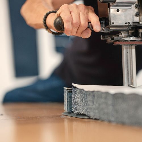 Gros plan sur la découpe de plusieurs couches de denim dans l’atelier Atelier TUFFERY - Atelier Tuffery