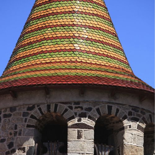 Gros plan sur les tuiles vernissées multicolores du clocher du Monastier-sur-Gazeille - Atelier Tuffery