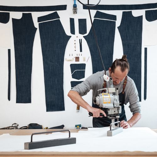 Artisan en train de découper un patron de jean dans l’atelier Atelier TUFFERY à Florac - Atelier Tuffery