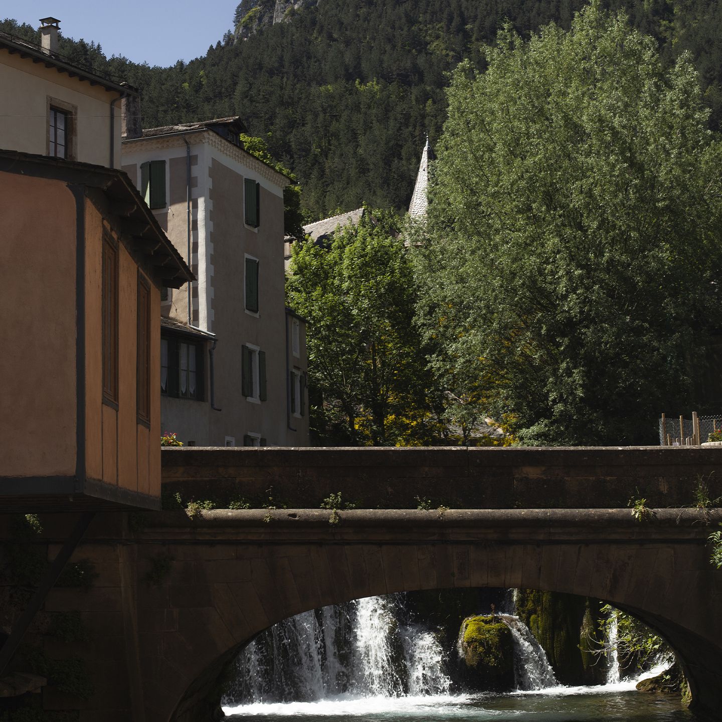 Vue d’un pont en pierre avec cascade à Florac | Atelier Tuffery