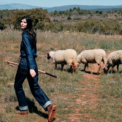 Bergère marchant aux côtés d’un troupeau de brebis sur les chemins de transhumance - Atelier Tuffery