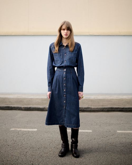 Modèle femme qui pose en full look denim avec la jupe en denim Louise et une chemise en denim - Atelier Tuffery