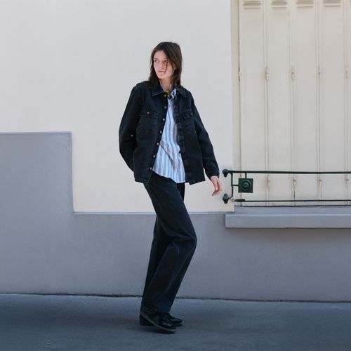 Une femme avec un jean noir et chemise rayée - Atelier Tuffery