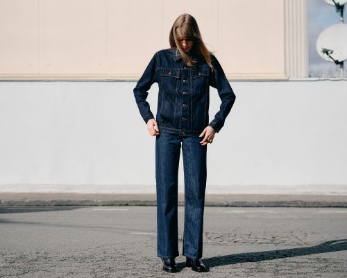 Modèle femme qui pose avec un look full denim et la veste Tuff's en jean brut - Atelier Tuffery