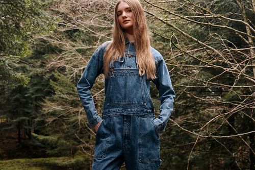 Salopette en denim Atelier Tuffery portée par une femme en forêt, esprit workwear authentique - Atelier Tuffery