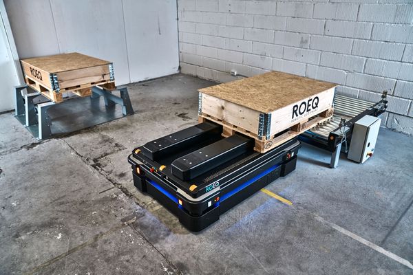A MiR1350 with the ROEQ TLR750 "Lift n Roll" Top module solution in a practical scenario moving pallets from a conveyor