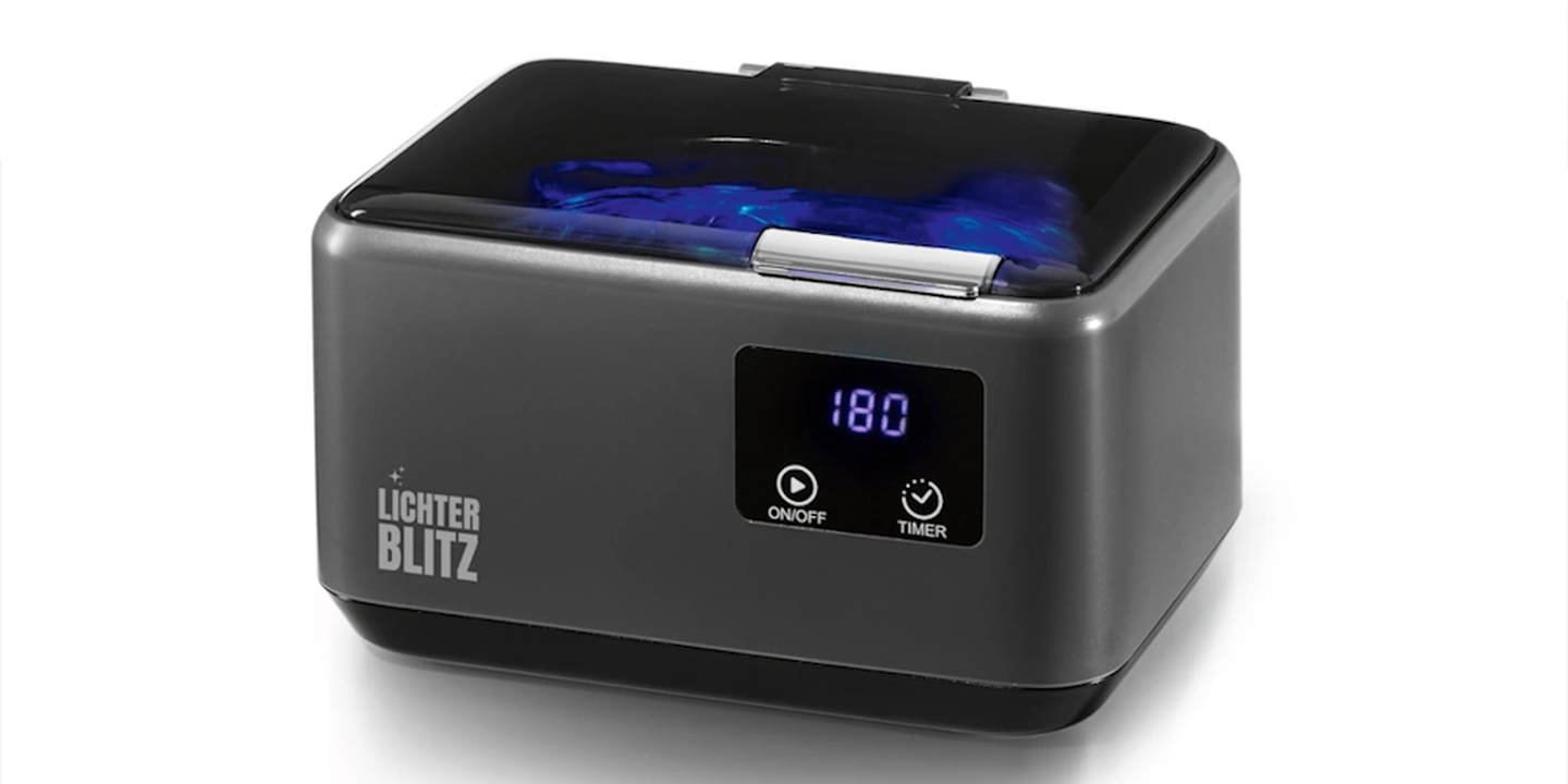 Ein kompaktes graues Ultraschall-Reinigungsgerät mit einer Digitalanzeige, auf der „180“ angezeigt wird, sowie Ein-/Aus- und Timer-Tasten.