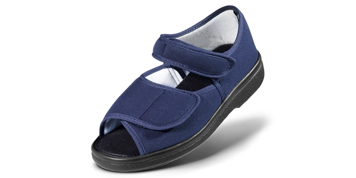 Marineblaue orthopädische Sandale mit großem Klettverschluss, offener Zehenpartie und schwarzer Gummisohle.