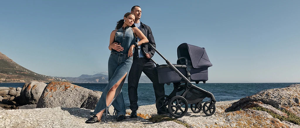 Ein Paar posiert neben einem Kinderwagen