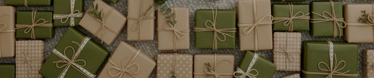 Zahlreiche grüne und beige Geschenkboxen, die mit Bindfaden und Bändern umwickelt sind, sind auf einer strukturierten Oberfläche arrangiert.