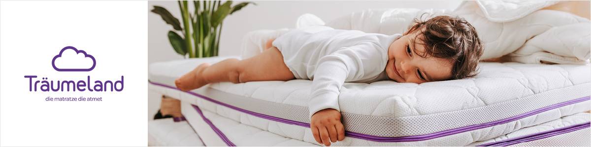 Ein Kind schläft friedlich auf einem Stapel Matratzen, umgeben von Bettwäsche, im Hintergrund ist eine Pflanze zu sehen. Links befindet sich das Logo von Träumeland.