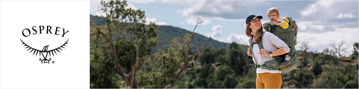 Eine Frau wandert mit einem Kind in einer Rückentrage auf einem Wanderweg, umgeben von Bäumen und Hügeln unter einem teilweise bewölkten Himmel; links das Osprey-Logo.
