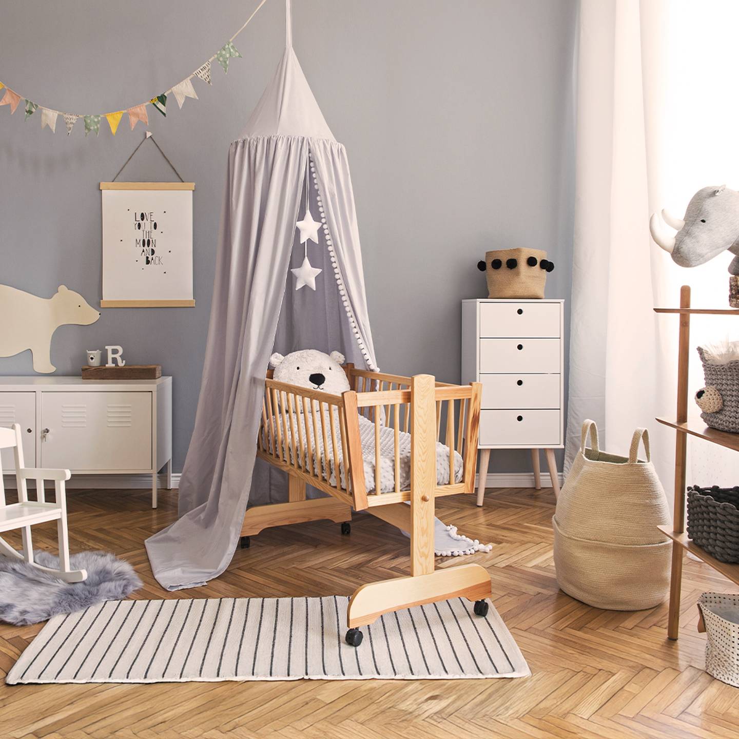 Gemütliches Kinderzimmer mit einem Holzbett, Baldachin, Schaukelstuhl und Stofftieren. Neutrale Töne und weiche Texturen schaffen eine beruhigende Atmosphäre.