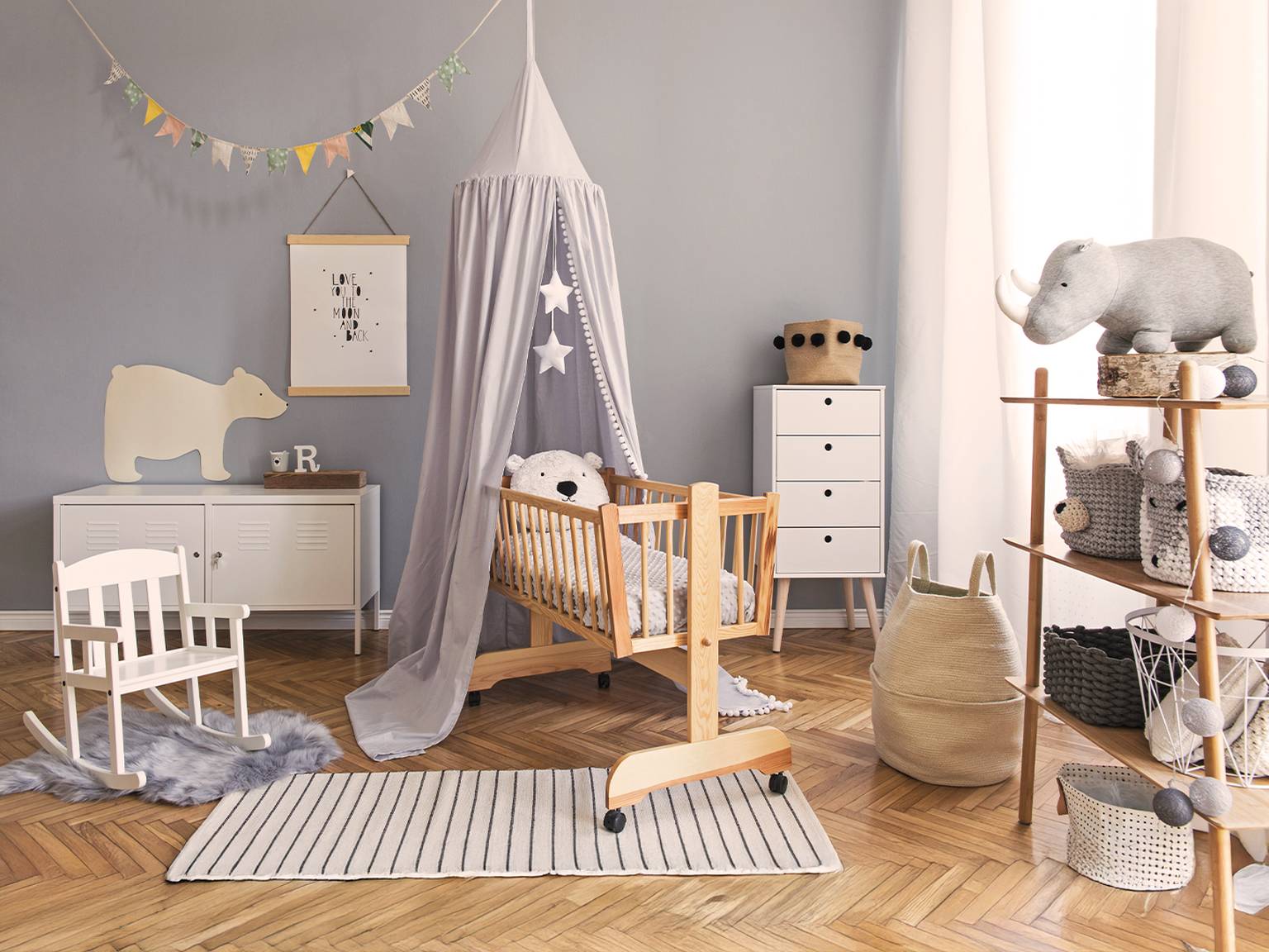 Gemütliches Kinderzimmer mit einem Holzbett, Baldachin, Schaukelstuhl und Stofftieren. Neutrale Töne und weiche Texturen schaffen eine beruhigende Atmosphäre.
