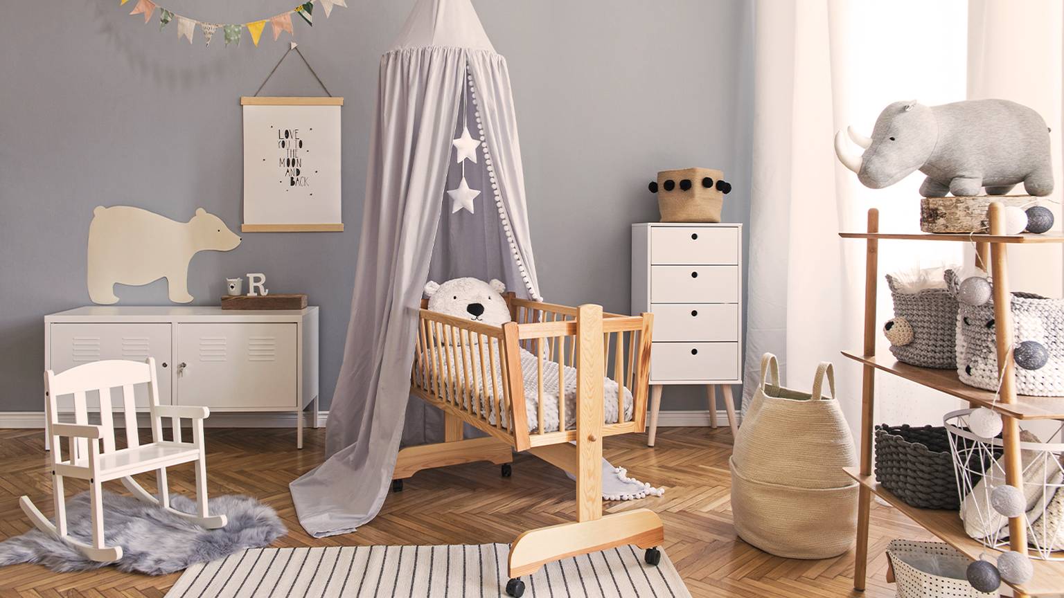 Gemütliches Kinderzimmer mit einem Holzbett, Baldachin, Schaukelstuhl und Stofftieren. Neutrale Töne und weiche Texturen schaffen eine beruhigende Atmosphäre.