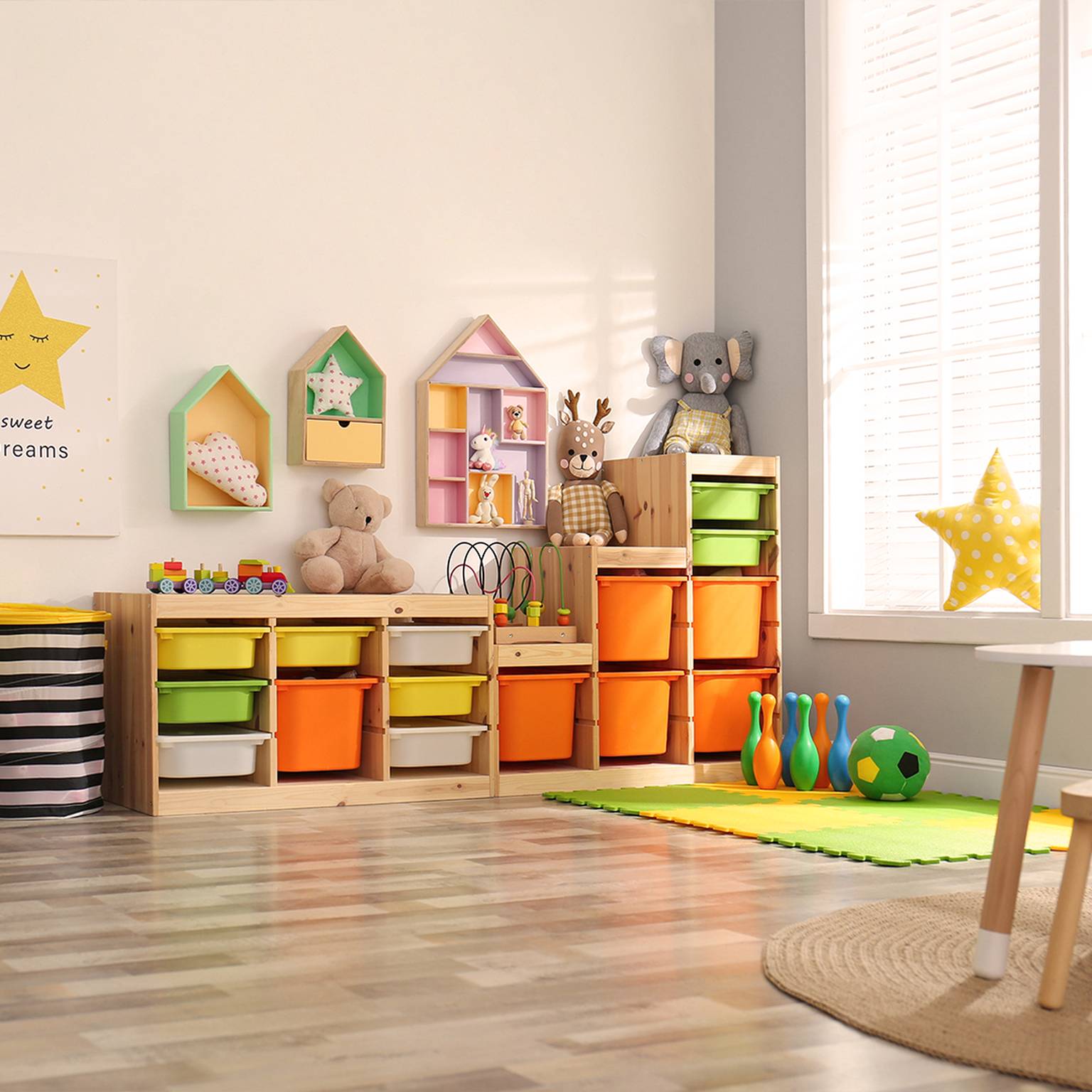 Helles Spielzimmer mit bunten Aufbewahrungsbehältern, Spielzeug, einem Giraffenplüschtier und Wanddekor. Sonnenlicht strömt durch große Fenster auf den Holzboden.