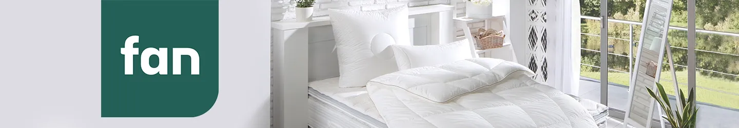 Gemütliches Schlafzimmer mit einer weichen, weißen Bettdecke und Kissen. Große Fenster bieten einen malerischen Ausblick, und links ist ein Logo mit dem Wort „Fan“ auf grünem Hintergrund zu sehen.