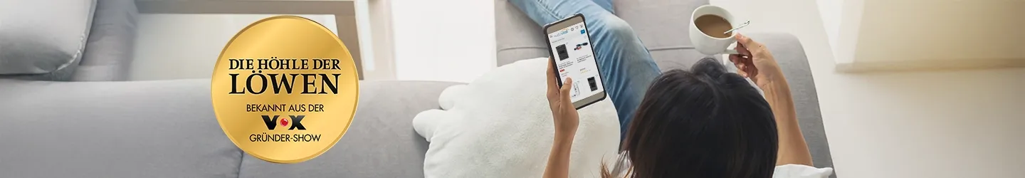 Person auf einer Couch, die ein Tablet benutzt und eine Kaffeetasse hält. Ein goldenes Emblem mit der Aufschrift „Die Höhle der Löwen“ und darunter „VOX Gründer-Show“.