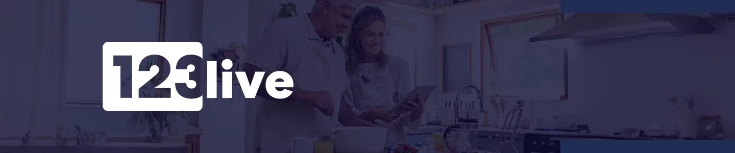 Älteres Ehepaar kocht in einer modernen Küche, lächelt, mit dem Text „123 live” auf der linken Seite.