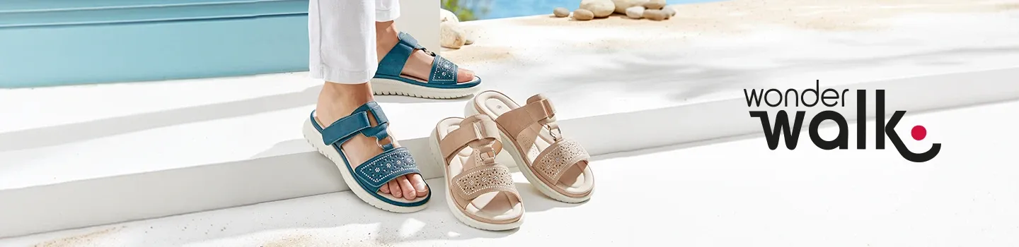 Eine Person in blauen Sandalen steht neben beigen Sandalen auf einem weißen Untergrund, im Hintergrund ist das „wonderwalk“-Logo zu sehen.