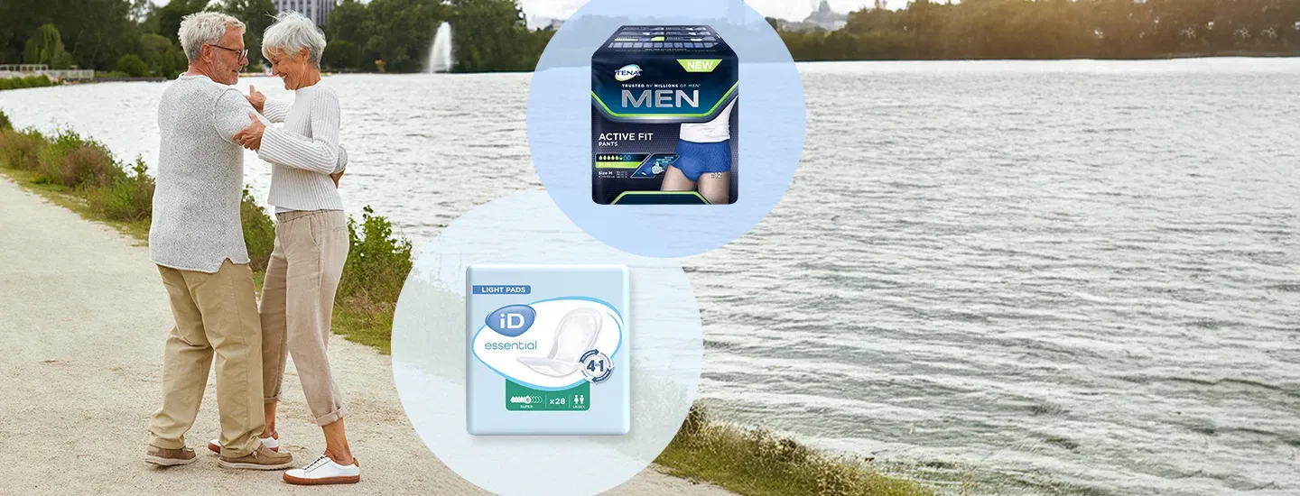 Zwei ältere Erwachsene stehen auf einem Weg am Seeufer, daneben sind die Inkontinenzprodukte TENA Men Active Fit Pants und iD Essential Light Pads abgebildet.