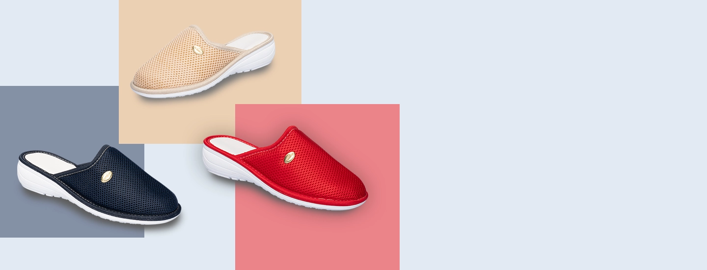 Drei Paar Hausschuhe, eines in blau, eines in beige und eines in rot auf farblich abgesetztem Hintergrund.