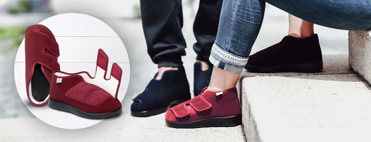 Roter orthopädischer Schuh mit Klettverschluss, der durch ein herausnehmbares Innenfutter besticht. Rechts sitzen zwei Personen auf einer Treppe und tragen ähnliche Schuhe, einer rot, einer schwarz.