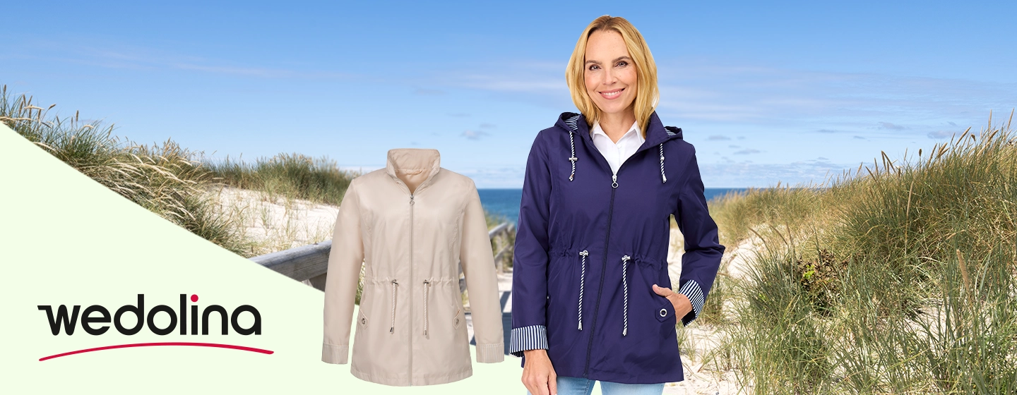 Eine Frau in einer dunkelblauen Jacke steht auf einem sandigen Weg am Strand, neben ihr liegt eine beige Jacke. Das „Wedolina“-Logo ist zu sehen.