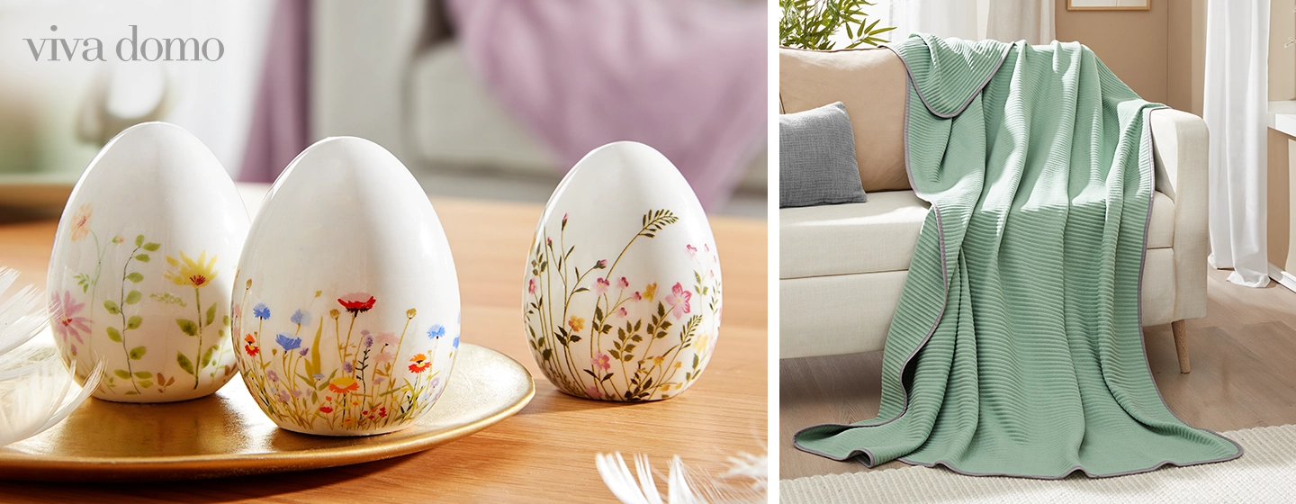 Drei dekorative Eier mit Blumenmustern stehen auf einem Holztisch; eine grüne Decke liegt über einem beigen Sofa.