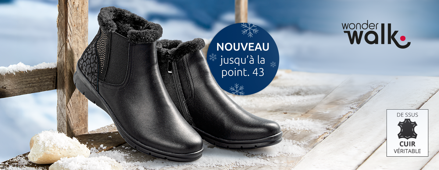 Schwarze, mit Fell gefütterte Winter-Stiefeletten auf einer verschneiten Holzfläche mit „Wonderwalk“-Logo und Leder-Materialetikett. Erhältlich bis Größe 43.