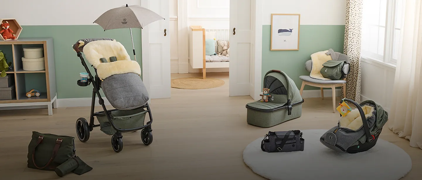 Kinderzimmer mit Kinderwagen, Autositz und Babyzubehör. Sanfte Grün- und Beigetöne sorgen für eine gemütliche Atmosphäre.