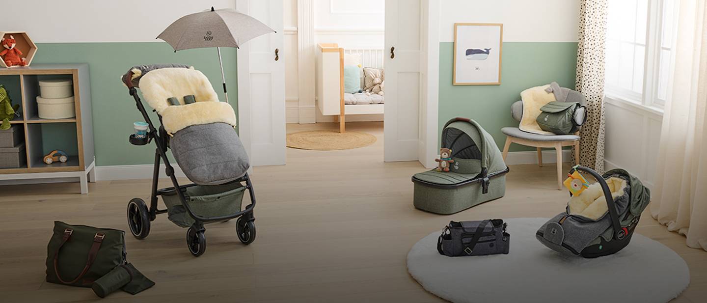 Kinderzimmer mit Kinderwagen, Autositz und Babyzubehör. Sanfte Grün- und Beigetöne sorgen für eine gemütliche Atmosphäre.