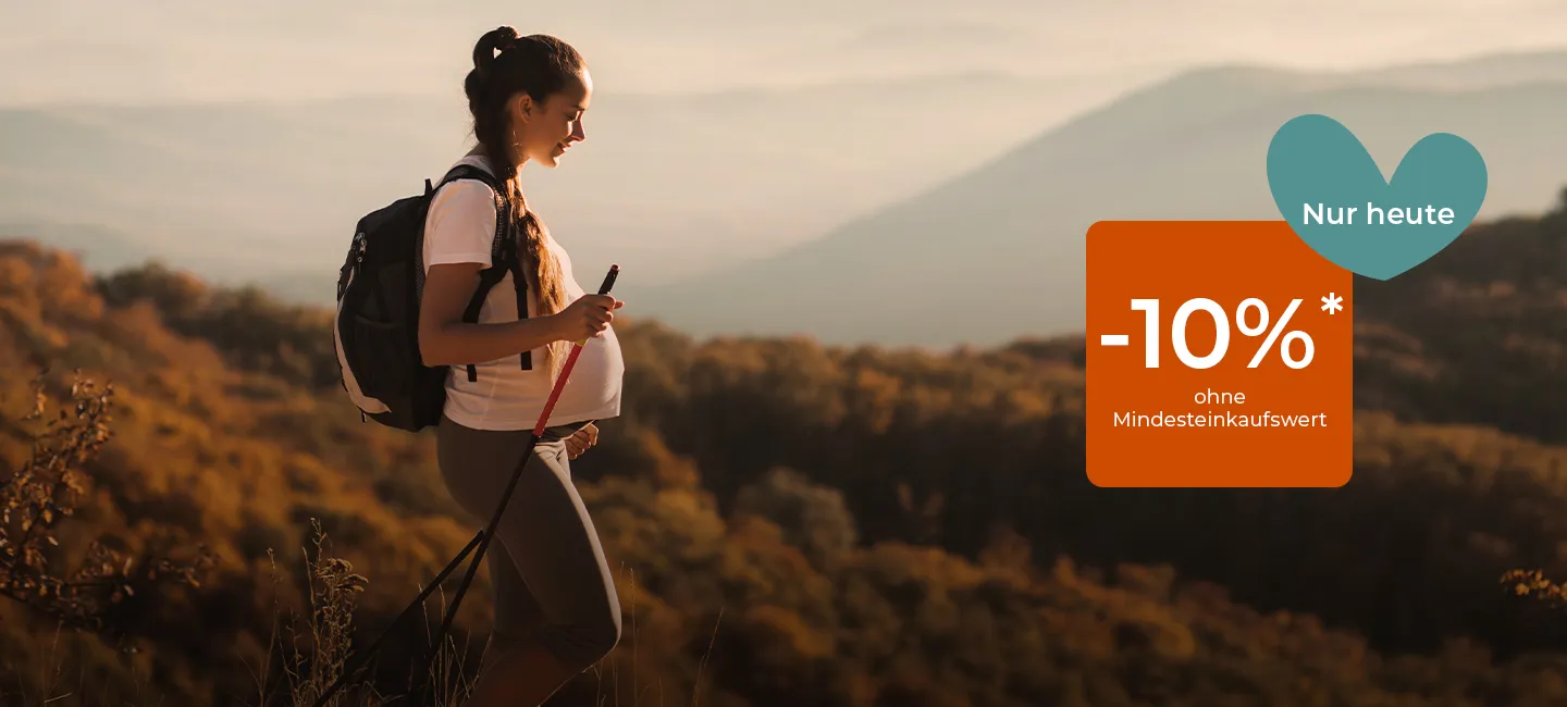 Schwangere wandert bei Sonnenuntergang mit Trekkingstöcken und trägt einen Rucksack. Rabatt-Overlay: „-10 %* ohne Mindesteinkaufswert, Nur heute.“