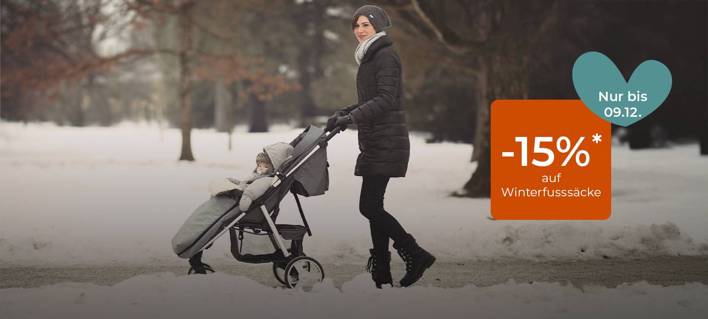 Frau im Wintermantel schiebt Kinderwagen mit dick eingepacktem Kind durch verschneiten Park; orangefarbenes Schild mit der Aufschrift "-15% auf Winterfußsäcke".