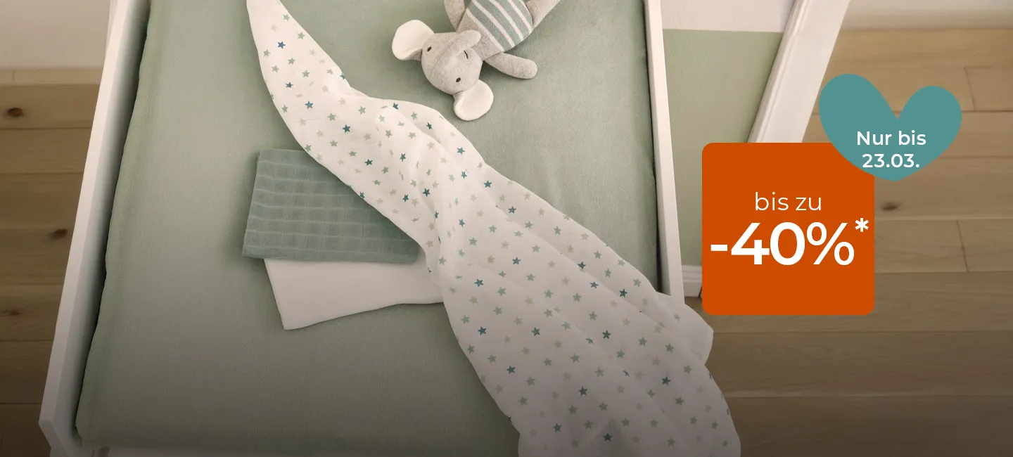Kinderbett mit grüner Bettwäsche, einer Stoffmaus und einer Decke mit Sternenmuster. Ein herz- und quadratförmiges Overlay zeigt „bis zu -40%“ und „Nur bis 23.03“.