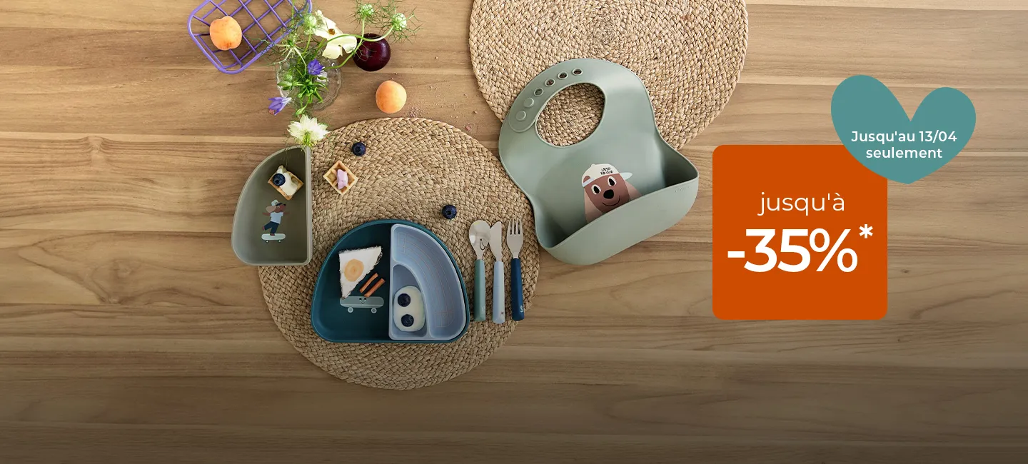 Service de table pour enfants sur une surface en bois avec des fleurs, des en-cas et une pancarte publicitaire offrant jusqu'à 35 % de réduction sur un fond en forme de cœur.