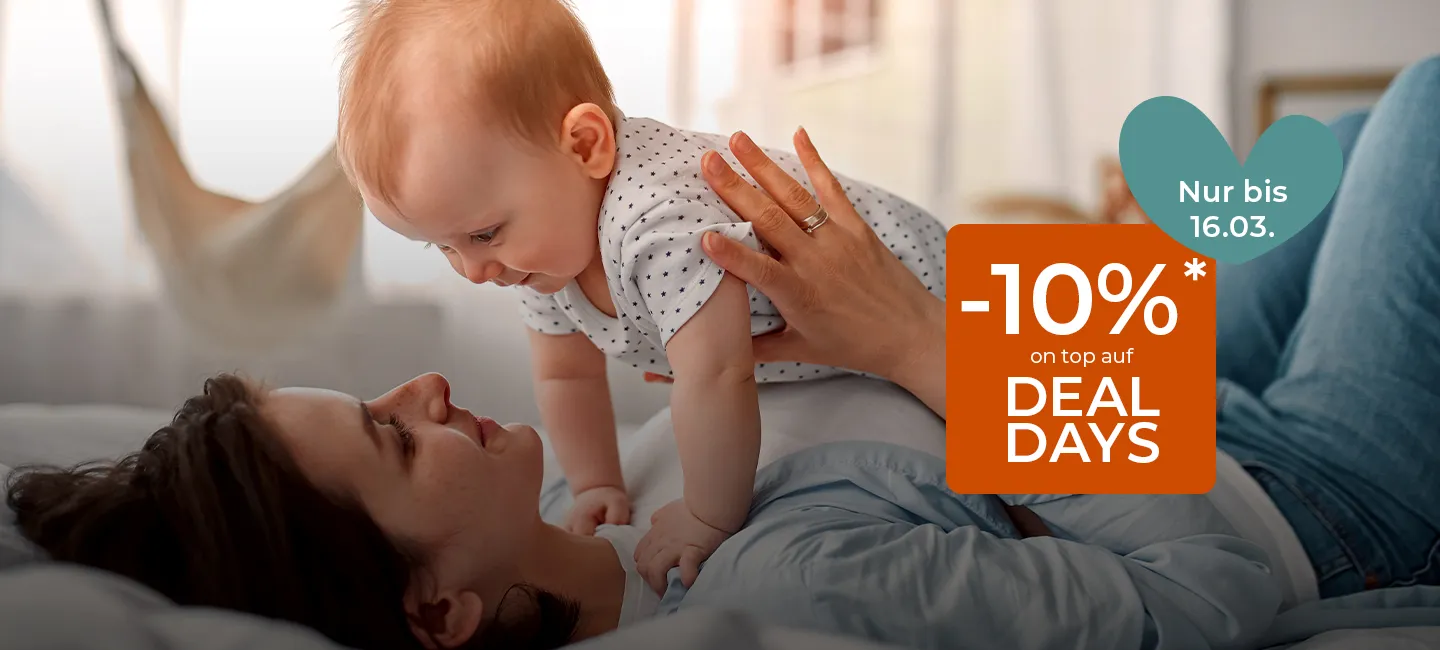 Eine liegende Frau hält ein Baby über sich. Das Bild enthält in einem Textfeld ein Angebot mit dem Titel „-10% on top auf Deal Days“, das am 16. März abläuft.