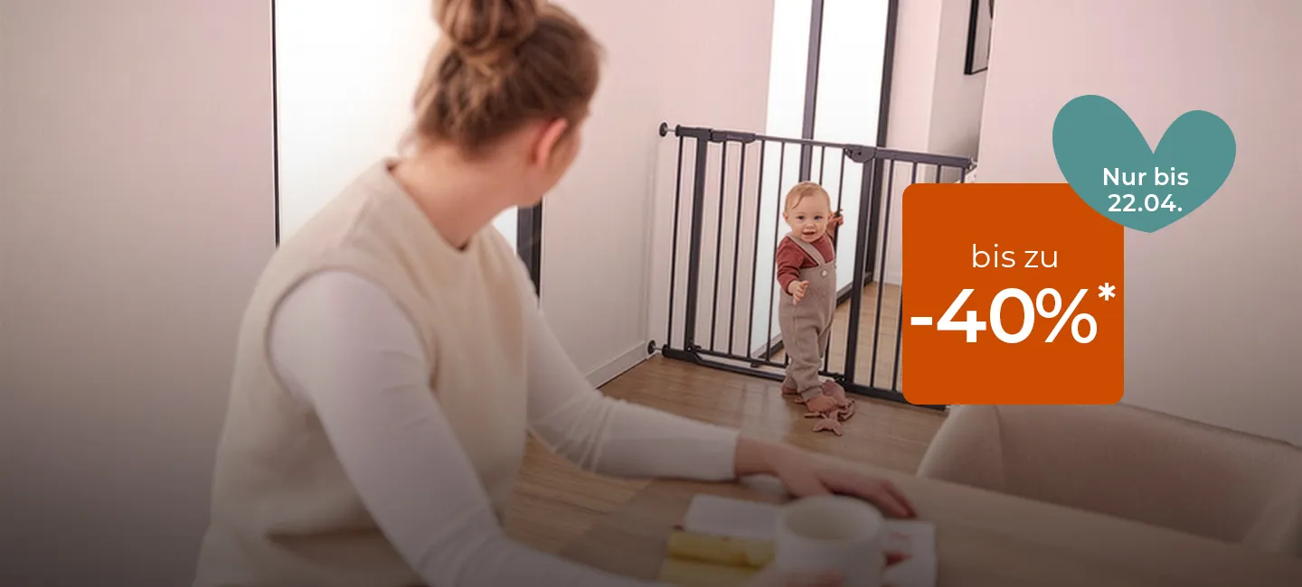 Eine Frau sitzt an einem Tisch und beobachtet ein Kind hinter einem Schutzgitter. Ein Rabattschild verspricht bis zu -40 %* Ermäßigung, gültig bis zum 22.04.