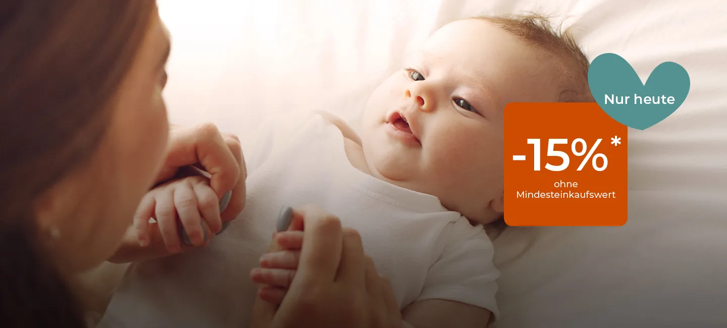 Ein Baby liegt auf einem Bett und schaut eine Person an. Darüber prangt ein Werbebanner, das einen Rabatt von 15 % nur für einen Tag anbietet.