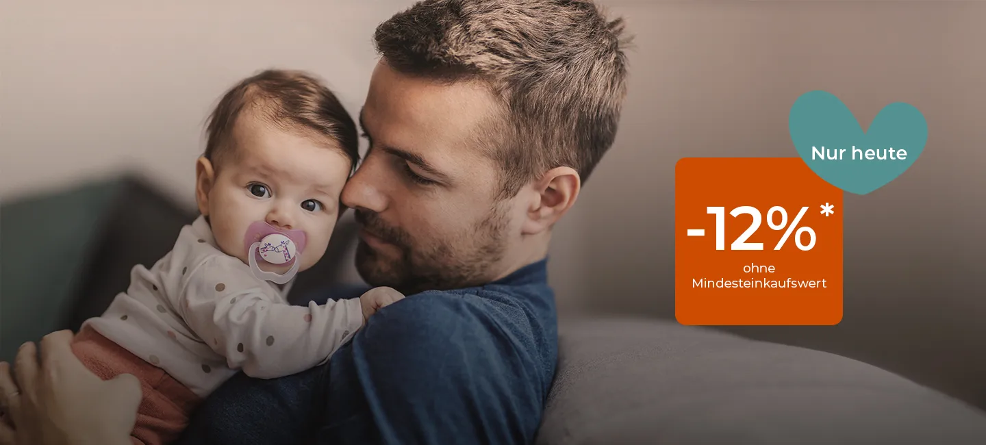 Ein Mann hält liebevoll ein Baby mit Schnuller im Arm. Textüberlagerung: „-12% ohne Mindesteinkaufswert, nur heute“ mit Herzform.