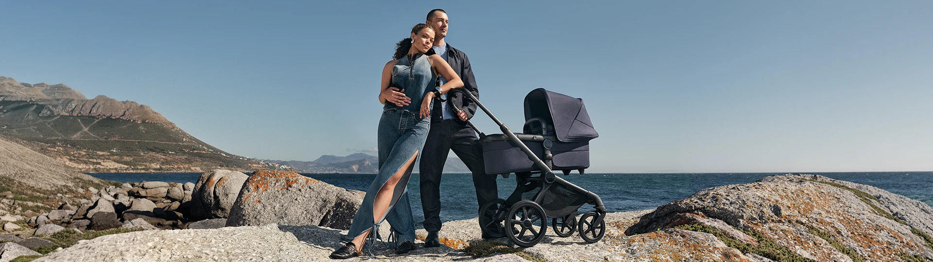 Ein Paar posiert neben einem Kinderwagen
