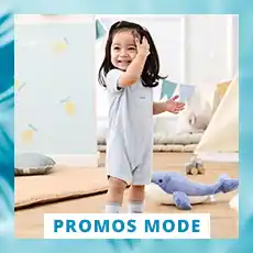 Dans une salle de jeux, un tout-petit vêtu d'une barboteuse bleu clair sourit à côté d'un dauphin en peluche. Une banderole portant l'inscription « Promos Mode » est visible sur la photo.