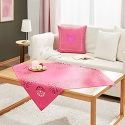 Rosa Tischdecke mit dekorativem Muster auf Couchtisch, stilvolle Wohntextilie für Wohnzimmer und gemütliche Atmosphäre.