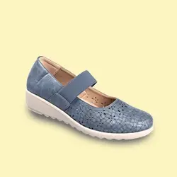 Blauer Mary-Jane-Schuh mit perforiertem Design, elastischem Riemen und weißer Keilsohle vor hellgelbem Hintergrund.