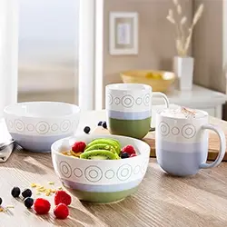 Moderne Keramikschalen und Tassen in Weiß und Grün mit Frühstückszutaten, stilvolles Geschirrset für Alltag und Genussmomente.