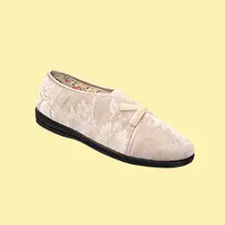 Cremefarbener Slipper mit Blumenmuster, schwarzer Sohle und einer kleinen Schleife oben, vor hellgelbem Hintergrund.