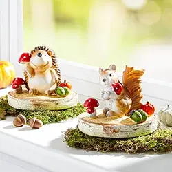 Liebevoll gestaltete Dekofiguren mit Igel und Eichhörnchen auf Holzscheiben, natürliche Herbstdekoration für Fensterbank und Wohnbereich.