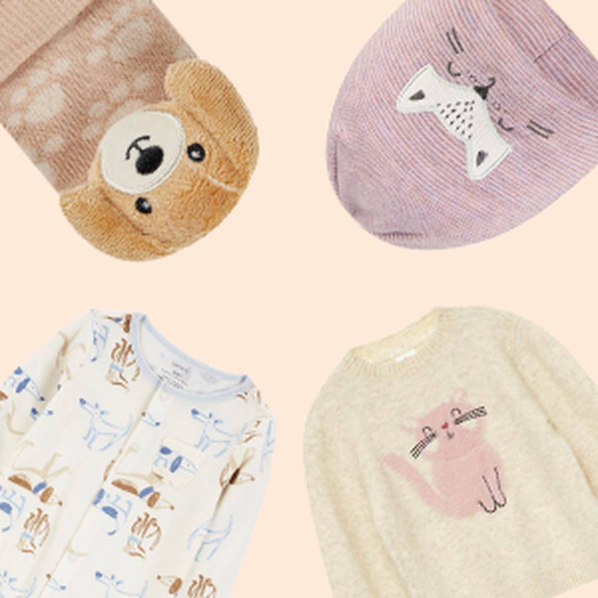 Verschiedene Babykleidung mit Tiermotiven, darunter Socken mit einem Hundemotiv, eine Katzenmütze, ein Strampler mit Hundemuster und ein Pullover mit einer rosa Katze.