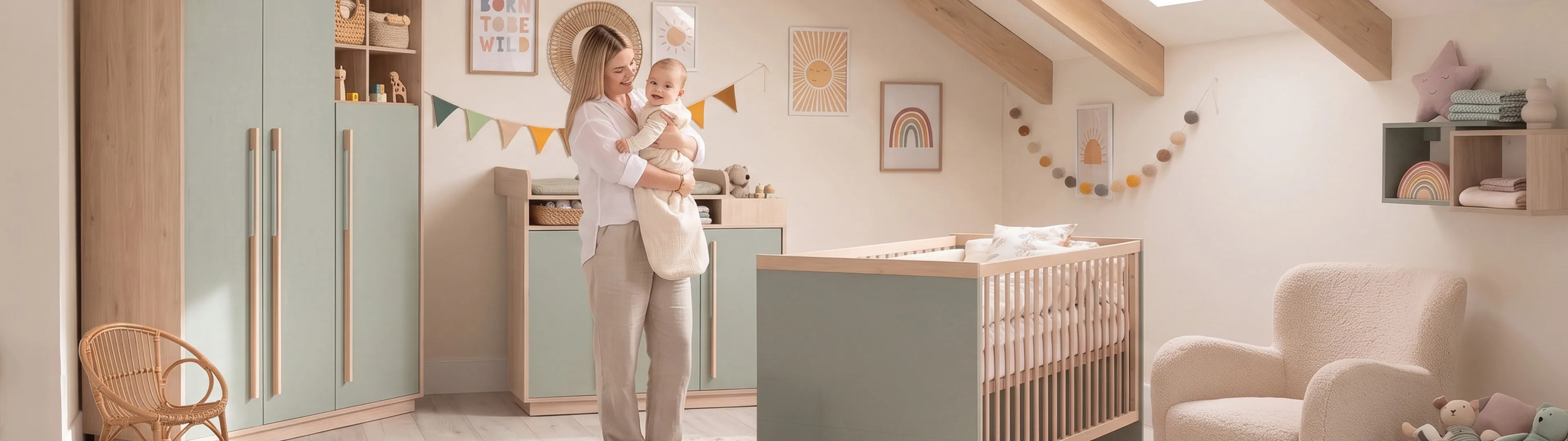 Eine lächelnde Frau hält ein Baby in einem pastellfarbenen Kinderzimmer mit Kinderbett, Plüschsessel und farbenfroher Wanddekoration unter einem Oberlicht.